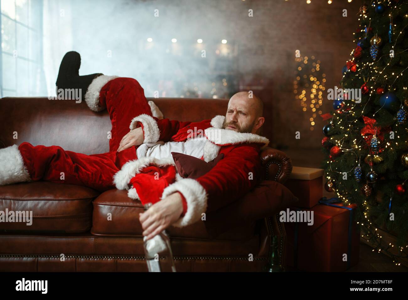 Babbo Natale ubriaco sdraiato sul divano dopo la festa Foto stock - Alamy