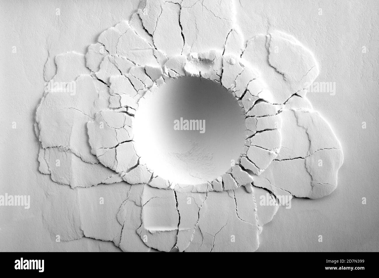 Un cratere su sfondo bianco a polvere. Cratere rotondo con crepe. Foto Stock