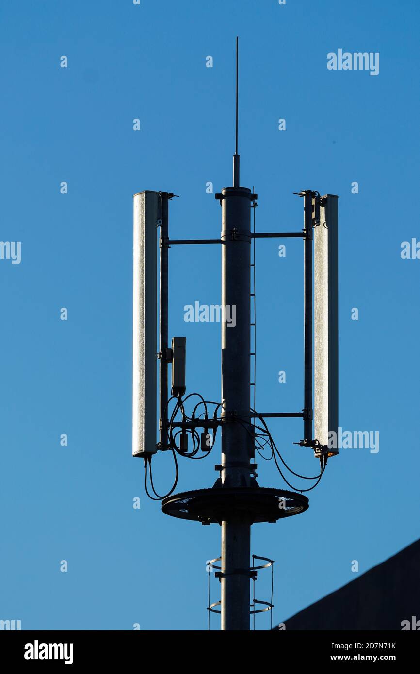 antenna e antenna per telecomunicazioni su un edificio contro un blu cielo Foto Stock