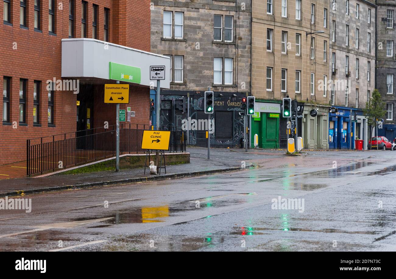 Leith, Edimburgo, Scozia, Regno Unito, 24 ottobre 2020. Primo vaccino contro l'influenza: Il primo giorno di tre fine settimana per vaccinazioni contro l'influenza drive-in per persone di età superiore a 65 anni e con persone con condizioni di salute si svolgono presso l'edificio del governo scozzese Victoria Quay in condizioni di tempo molto umido. Le persone sono chieste di frequentare in slot orarie secondo la prima lettera del loro cognome. Nella foto: Il cartello della clinica di influenza indica le indicazioni su Commercial Street Foto Stock