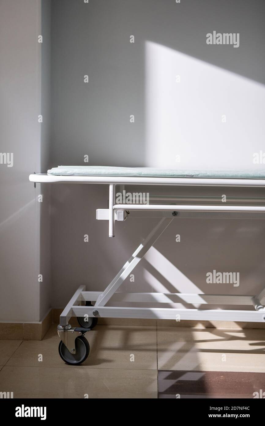 Carrello medico vuoto in piedi da parete e finestra in ospedale camera o corridoio Foto Stock