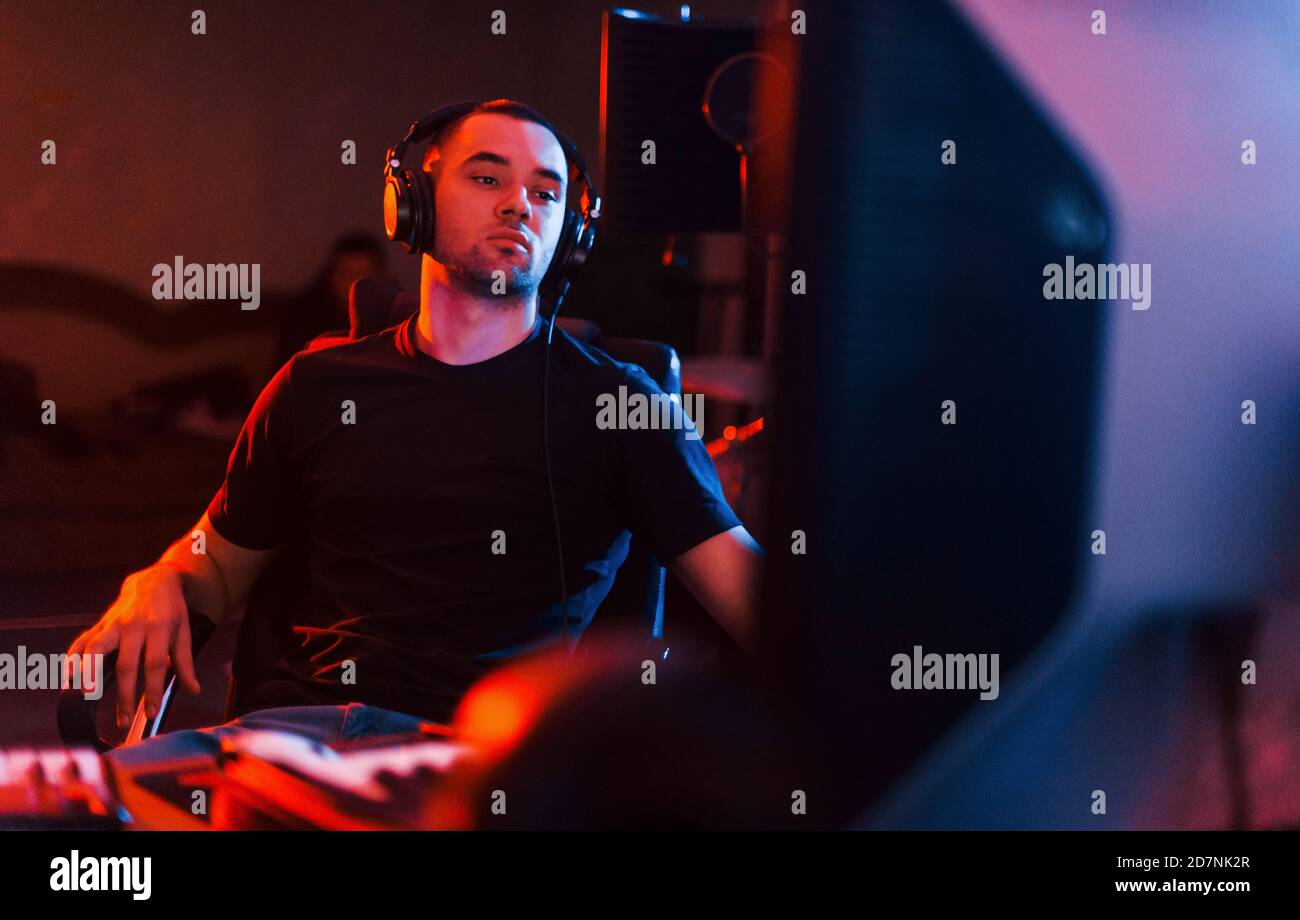 Tecnico del suono nelle cuffie che lavora e mixa musica in interni il monolocale Foto Stock