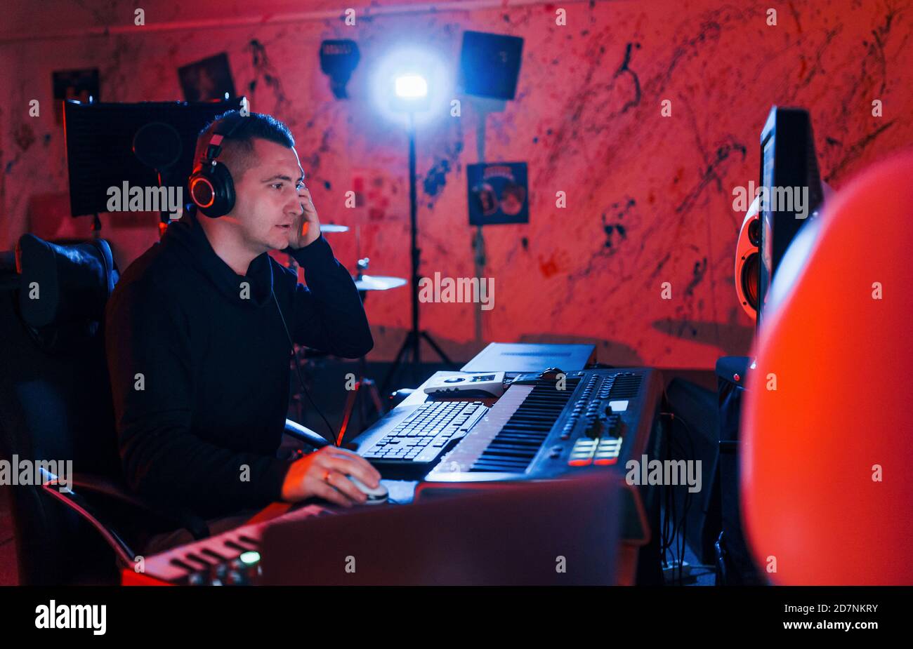 Un giovane tecnico di suono che lavora e mescola musica all'interno del studio Foto Stock