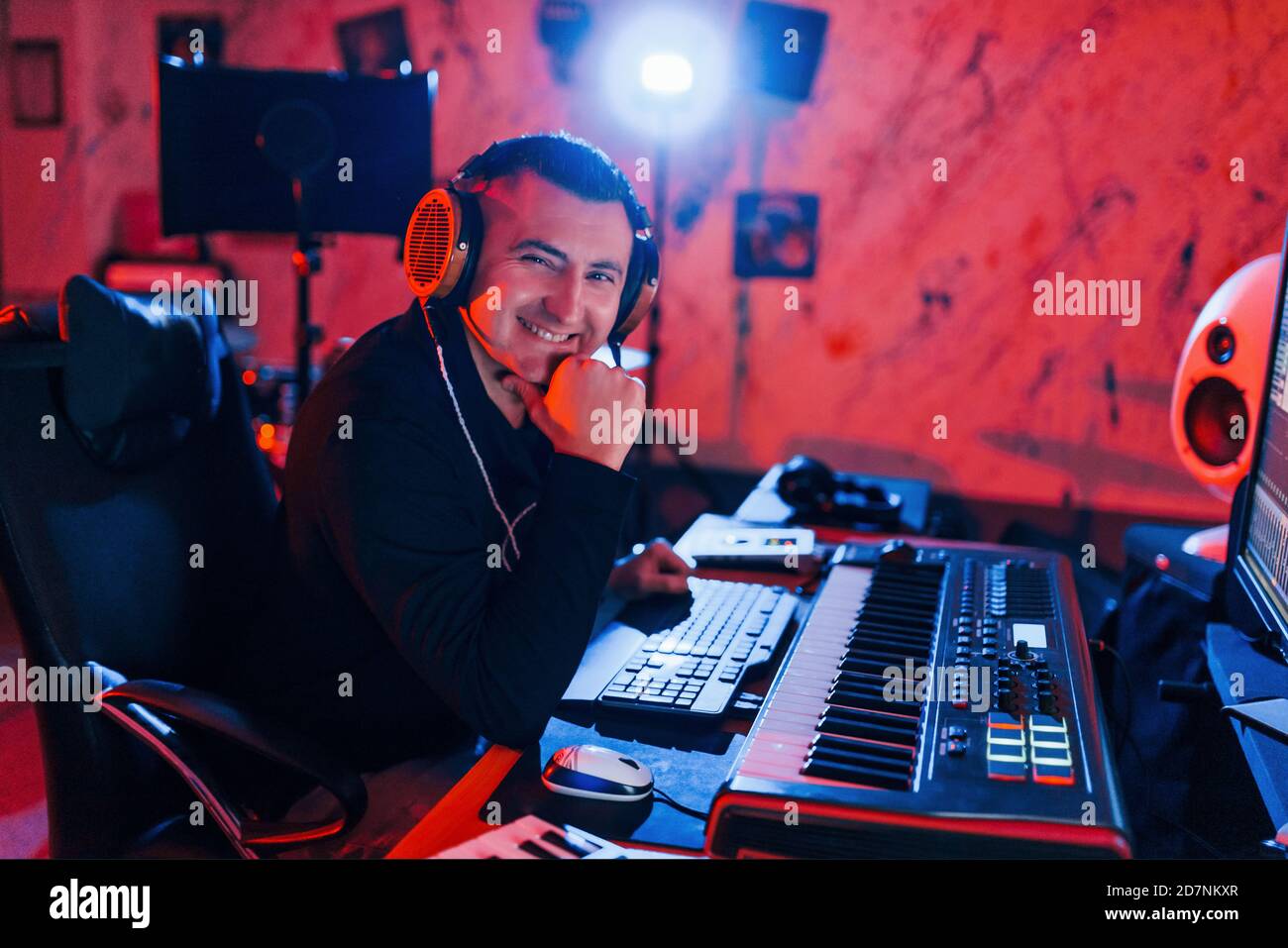 Un giovane tecnico di suono che lavora e mescola musica all'interno del studio Foto Stock