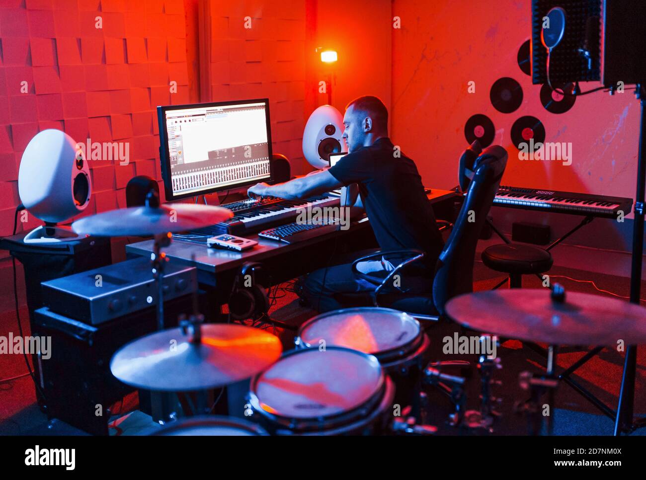 Un giovane tecnico di suono che lavora e mescola musica all'interno del studio Foto Stock