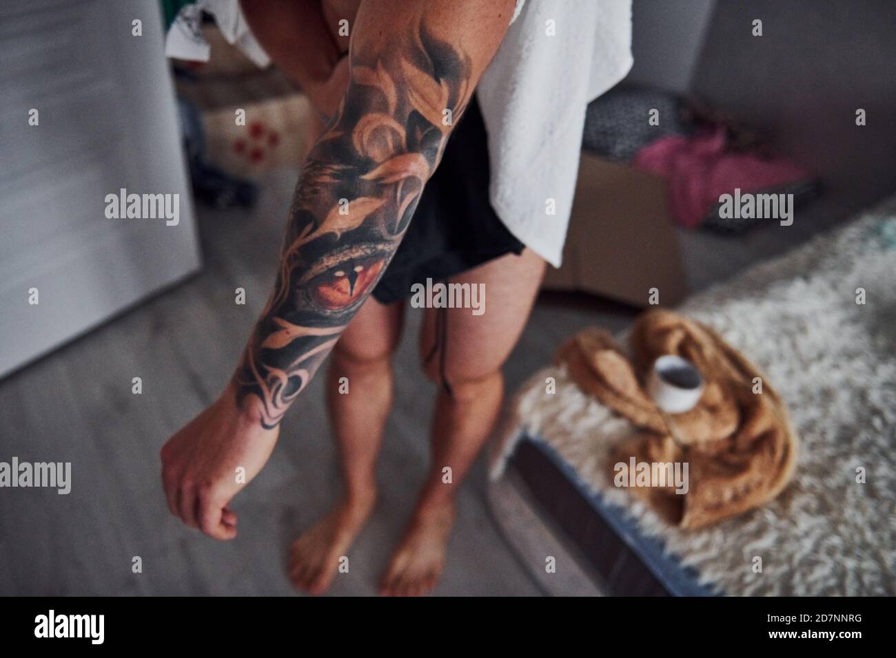 Guy mostra il suo tatuaggio sul braccio all'interno a casa dopo la doccia  Foto stock - Alamy