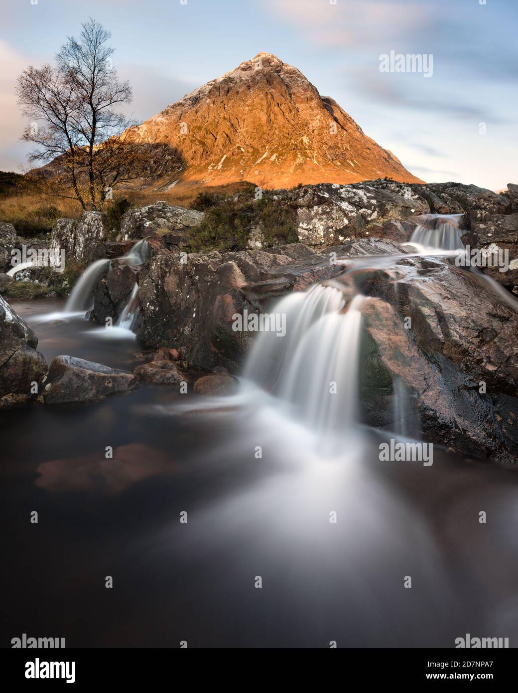 Famosa cascata Glencoe con la Buachaille sullo sfondo. Una mattina soleggiata con la luce che colpisce la cima della montagna. Foto Stock