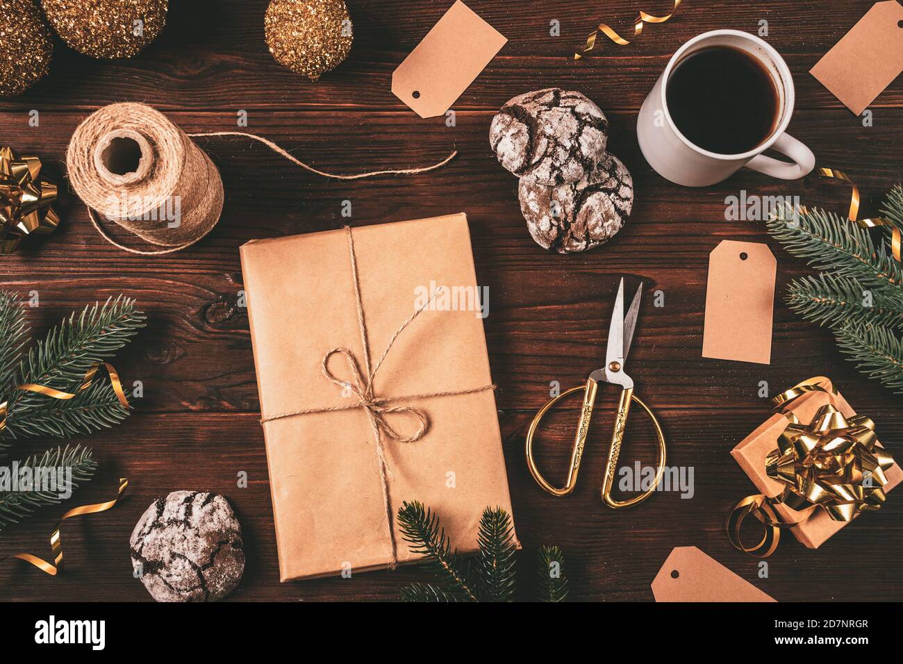 Composizione natalizia con scatola regalo artigianale, tazza di caffè,  biscotti, decorazioni dorate e forbici su tavolo di legno scuro, piatto  Foto stock - Alamy