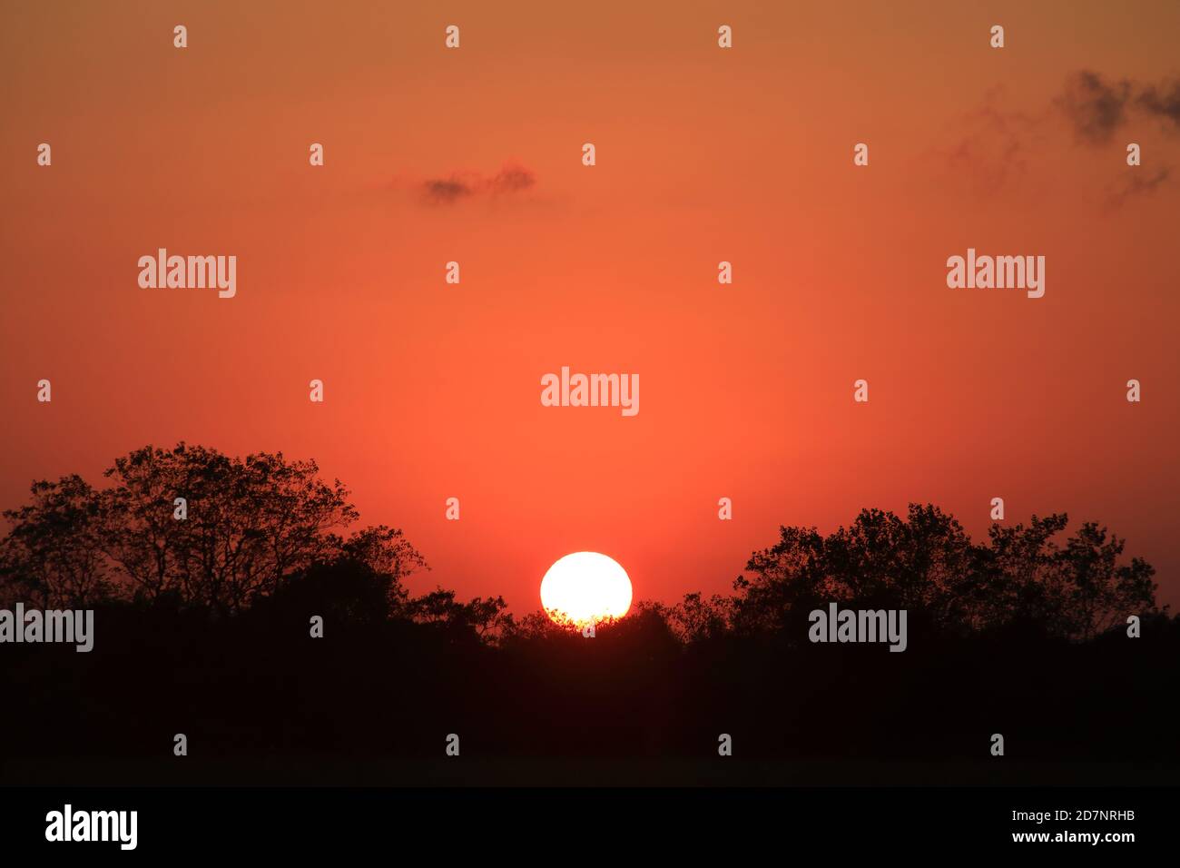 Cielo rosso con sole tramontante Foto Stock