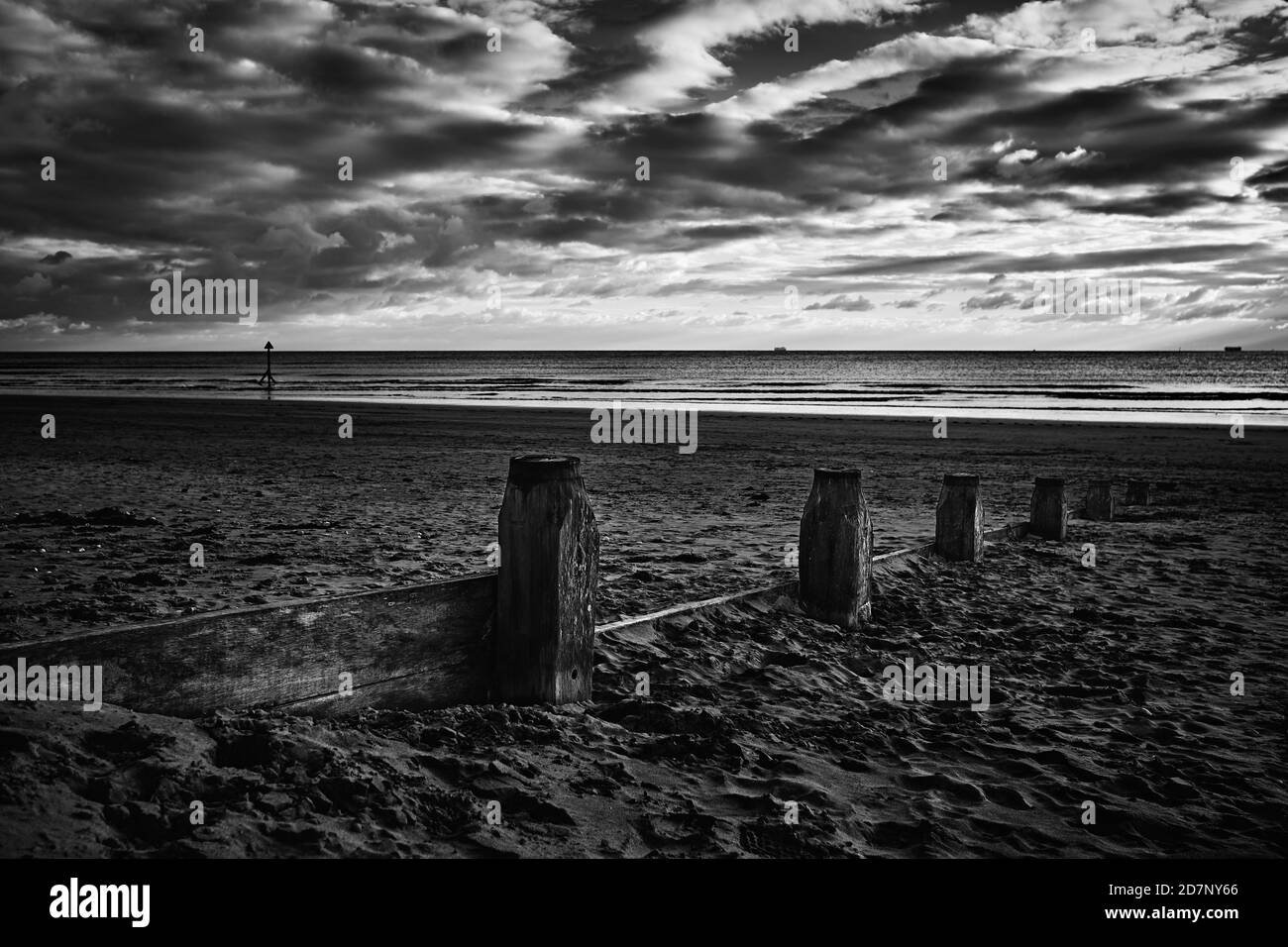 Gemelle bianche e nere lungo la spiaggia, cielo drammatico Foto Stock