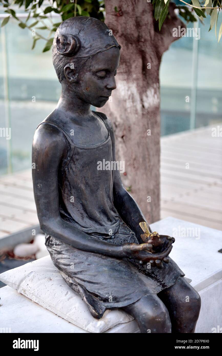 Scultura in bronzo nel centro storico di Paphos, "la ragazza con il passero" dell'artista cipriota Yiota Ioannidou, Foto Stock