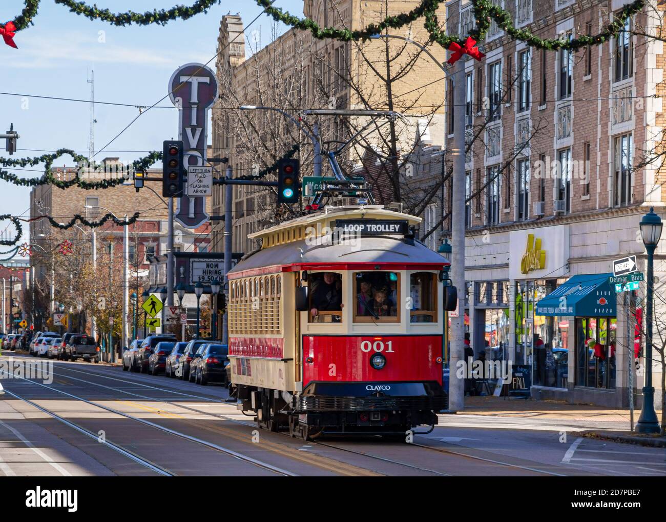 University City, Missouri--24 novembre 2018; tram antico rosso e giallo su del Mar Blvd a saint Louis con decorazioni natalizie appese sopra la strada e T Foto Stock