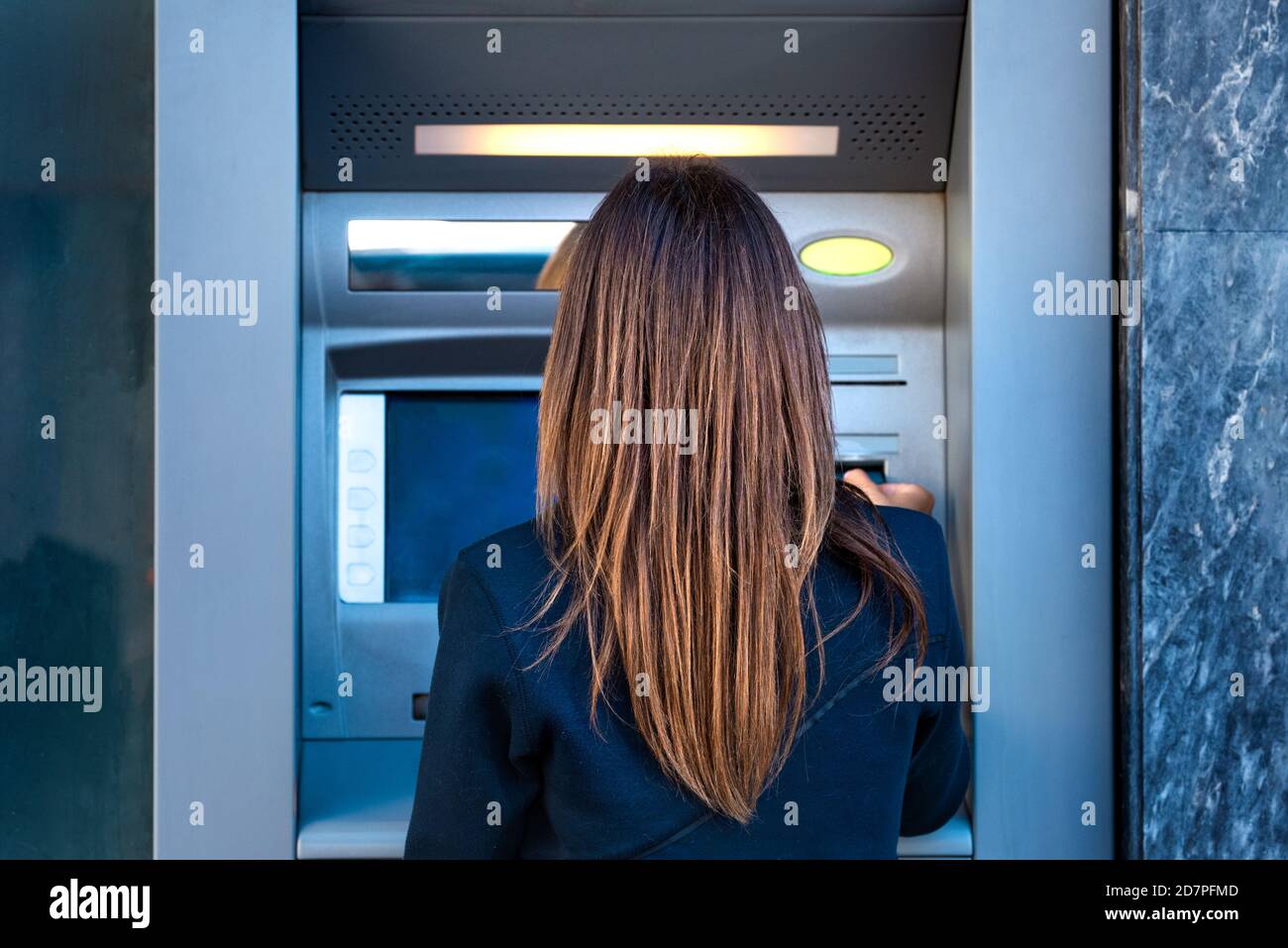 Donna che usa un bancomat. Prelievo di denaro contante dalla carta di credito presso la banca. Foto Stock