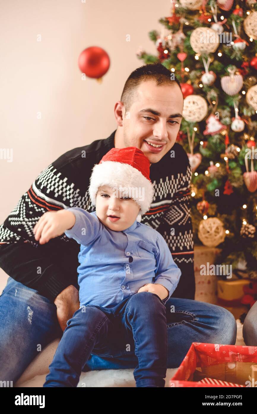 Padre con ragazzino festeggia il Natale - il ragazzo lancia Una palla di Natale Foto Stock