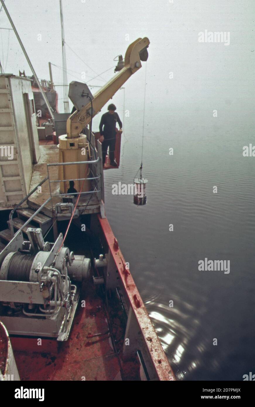 "La 'Marin Karlsen', una nave canadese, è un laboratorio galleggiante dal quale gli scienziati stanno analizzando le condizioni fisiche, chimiche biologiche e meteorologiche nel lago superiore. Tale studio completo di acqua dolce è chiamato limnologia. La rete di plancton viene abbassata in acqua per raccogliere campioni di zooplancton e fitoplancton; le forme più piccole di vita marina ca. 1973' Foto Stock