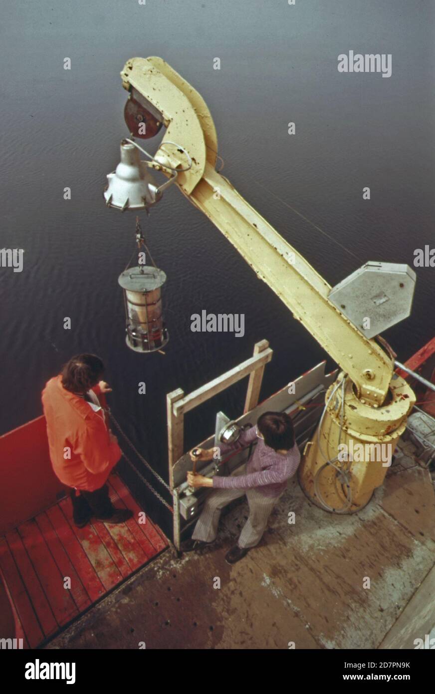 "La 'Marin Karlsen', una nave canadese, è un laboratorio galleggiante dal quale gli scienziati stanno analizzando le condizioni fisiche, chimiche biologiche e meteorologiche nel lago superiore. Tale studio completo di acqua dolce è chiamato limnologia. La rete di plancton viene abbassata in acqua per raccogliere campioni di zooplancton e fitoplancton; le forme più piccole di vita marina ca. 1973' Foto Stock