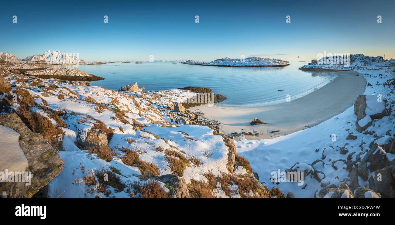 Spiaggia di sabbia bianca innevata in una baia invernale, mare blu, dietro Lofoten Peaks, Nordland, Lofoten, Norvegia Foto Stock Spiaggia di sabbia bianca innevata in una baia invernale, mare blu, dietro Lofoten Peaks, Nordland, Lofoten, Norvegia Foto Stock