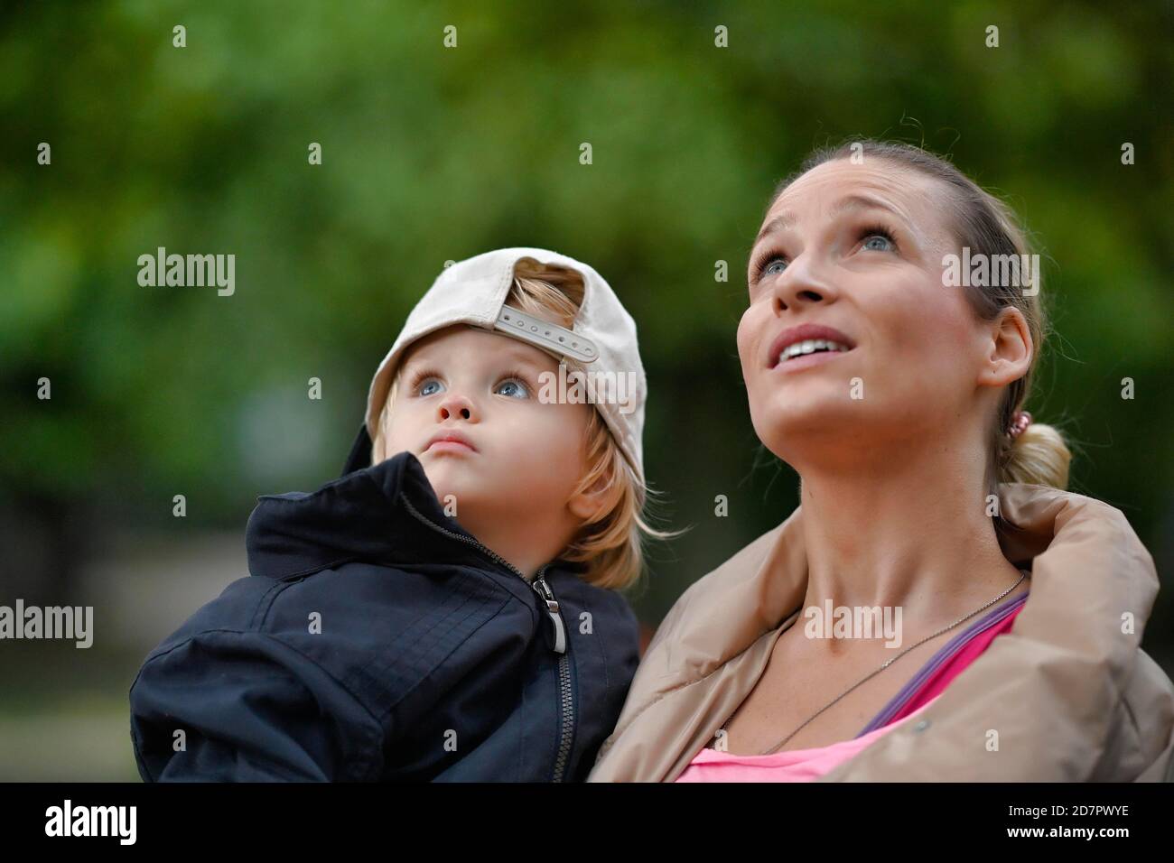 Madre che tiene il figlio, 2 anni, nelle sue braccia, guardando in su, Stoccarda Baden-Wuerttemberg, Germania Foto Stock