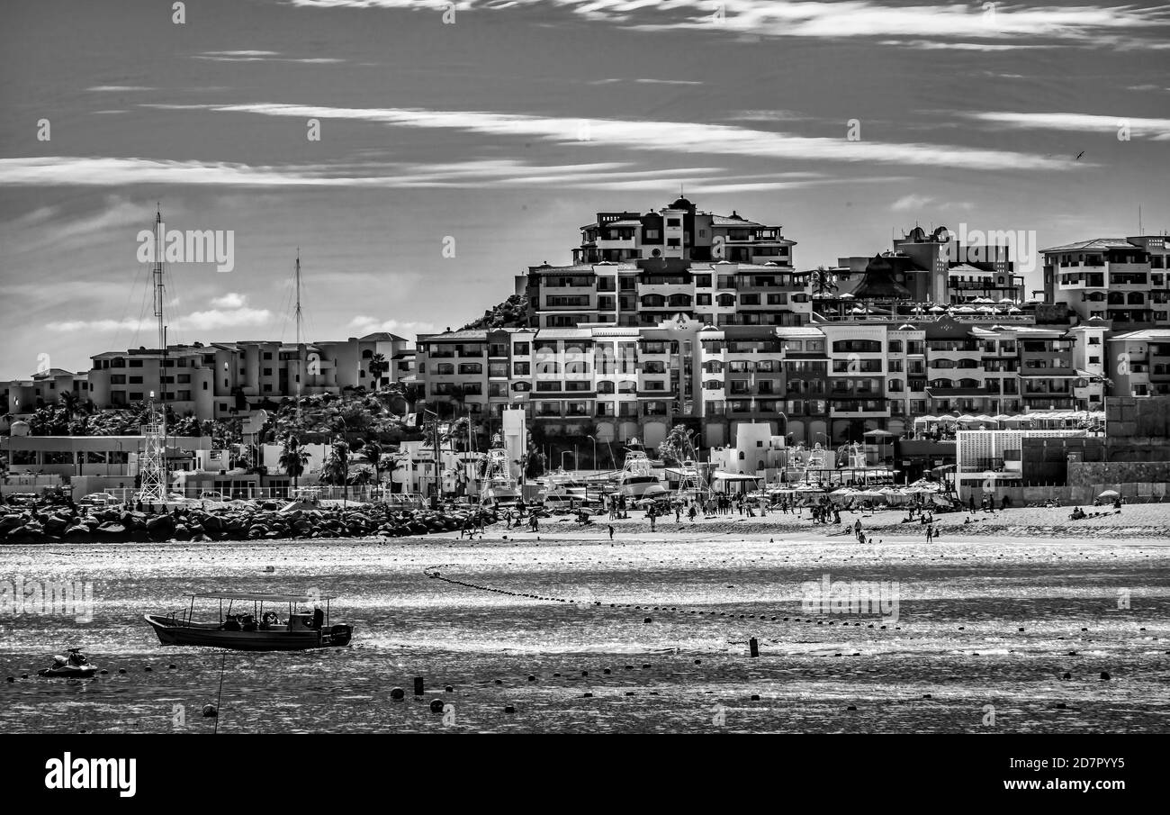 Spiaggia bianca e nera ristoranti Barche acqua Taxi nuotatori Cabo San Lucas Baja Messico. Los Cabos ha molti ristoranti su spiagge sabbiose. Foto Stock
