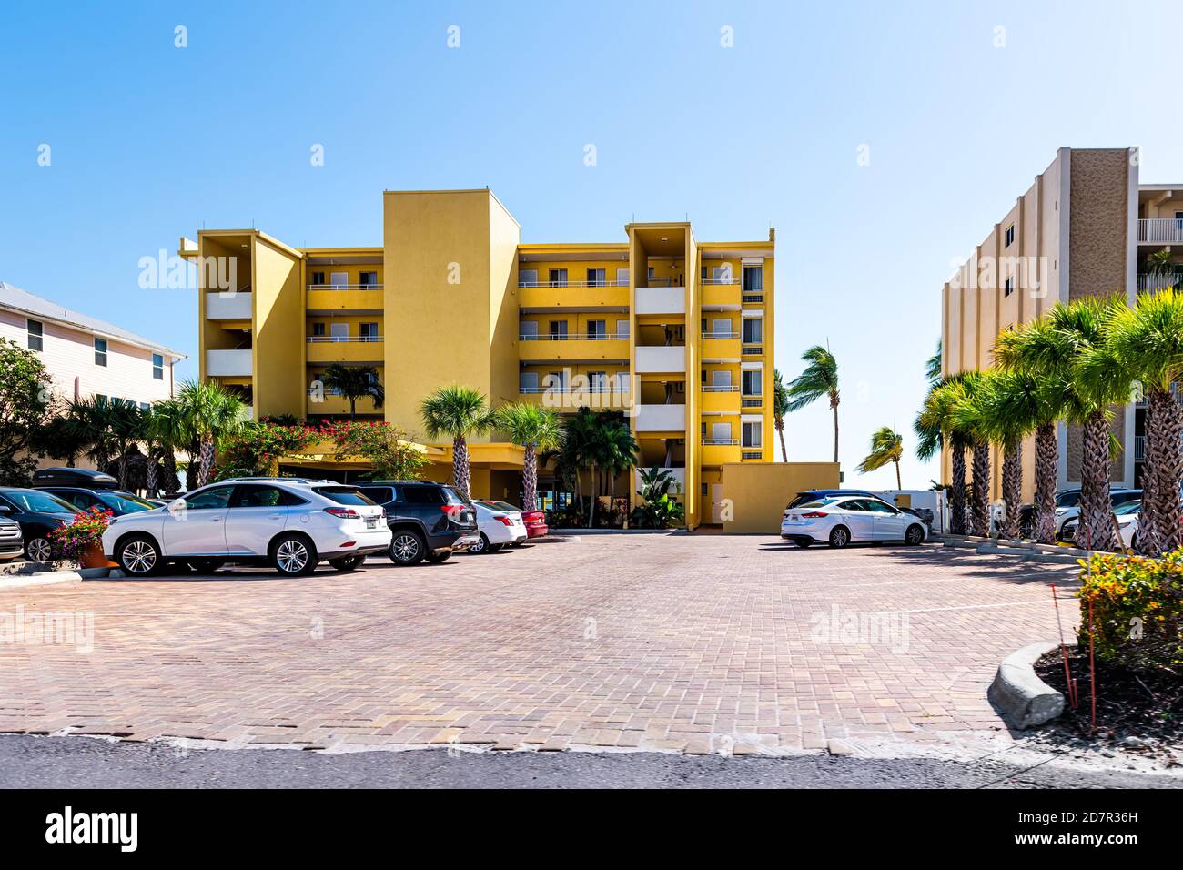 Fort Myers Beach, Stati Uniti d'America - 29 aprile 2018: Costa del golfo della Florida con colorato condominio giallo hotel edificio di appartamenti lungomare architettura e palme Foto Stock