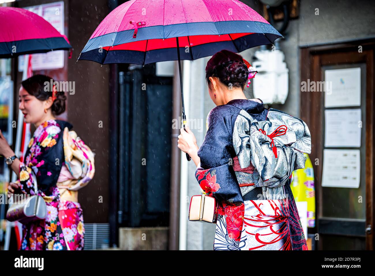 Kyoto, Giappone - 10 aprile 2019: Persone con ombrelli vestiti in costume kimono durante la piovosa strada giorno vicino al tempio Kiyomizu-dera Foto Stock