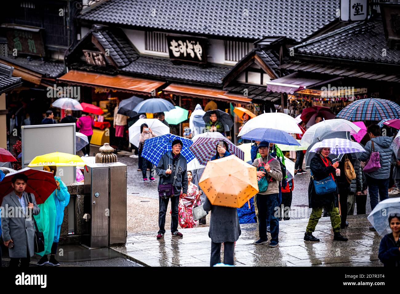 Kyoto, Giappone - 10 aprile 2019: Molte persone turisti con ombrelloni a piedi durante il giorno piovoso per strada vicino al tempio Kiyomizu-dera Foto Stock