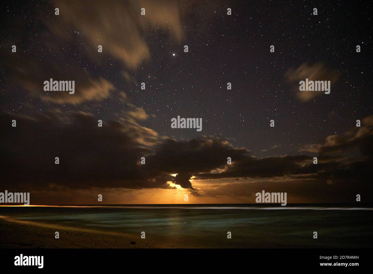 Luna che si affaccia sull'Oceano Pacifico, e stelle, Aroa Beach, Rarotonga, Isole Cook, Sud Pacifico Foto Stock