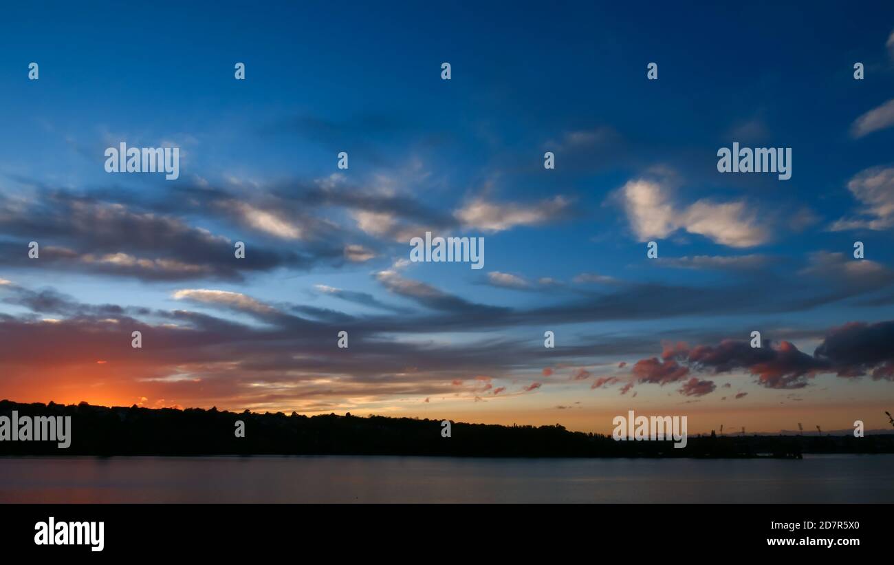 Incredibile tramonto sull'acqua. Splendido paesaggio con un lago e un cielo suggestivo con le nuvole di cumulo all'orizzonte. Foto Stock