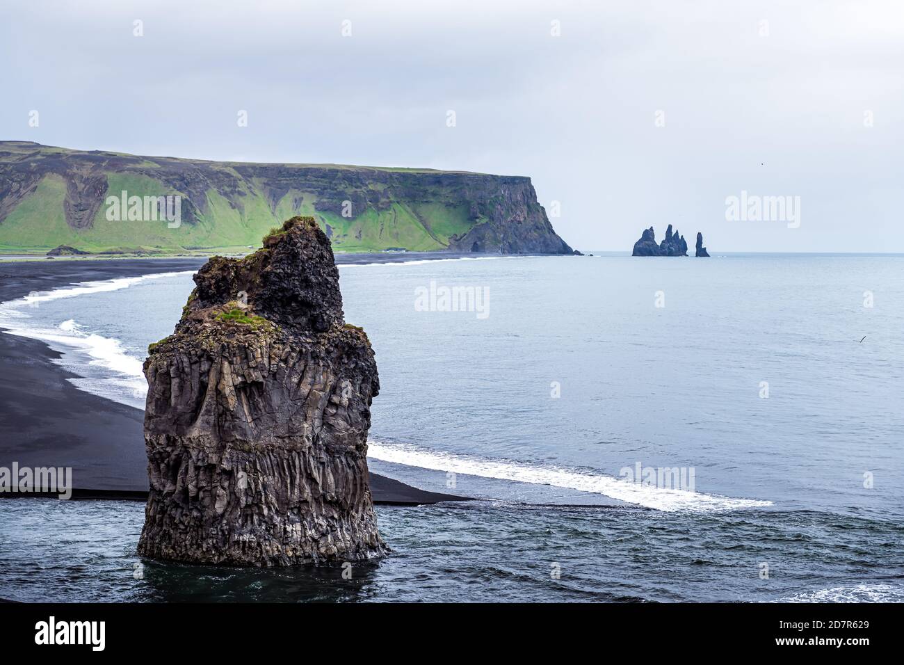 Myrdal, Islanda vista aerea ad alto angolo della spiaggia di sabbia nera di Reynisfjara e formazioni rocciose vulcaniche con costa costiera e onde che si infrangono Foto Stock