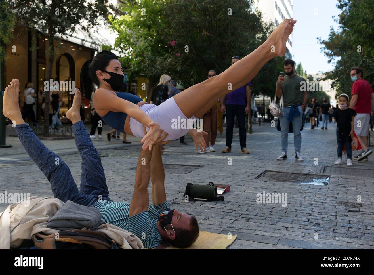 Atene, Grecia. 24 Ott 2020. Due ballerini di strada, indossando maschere facciali, si esibiscono nel centro di Atene, in Grecia, il 24 ottobre 2020. La Grecia il sabato ha segnalato altri 935 casi COVID-19 nelle ultime 24 ore, un nuovo record giornaliero. Credit: Marios Lolos/Xinhua/Alamy Live News Foto Stock