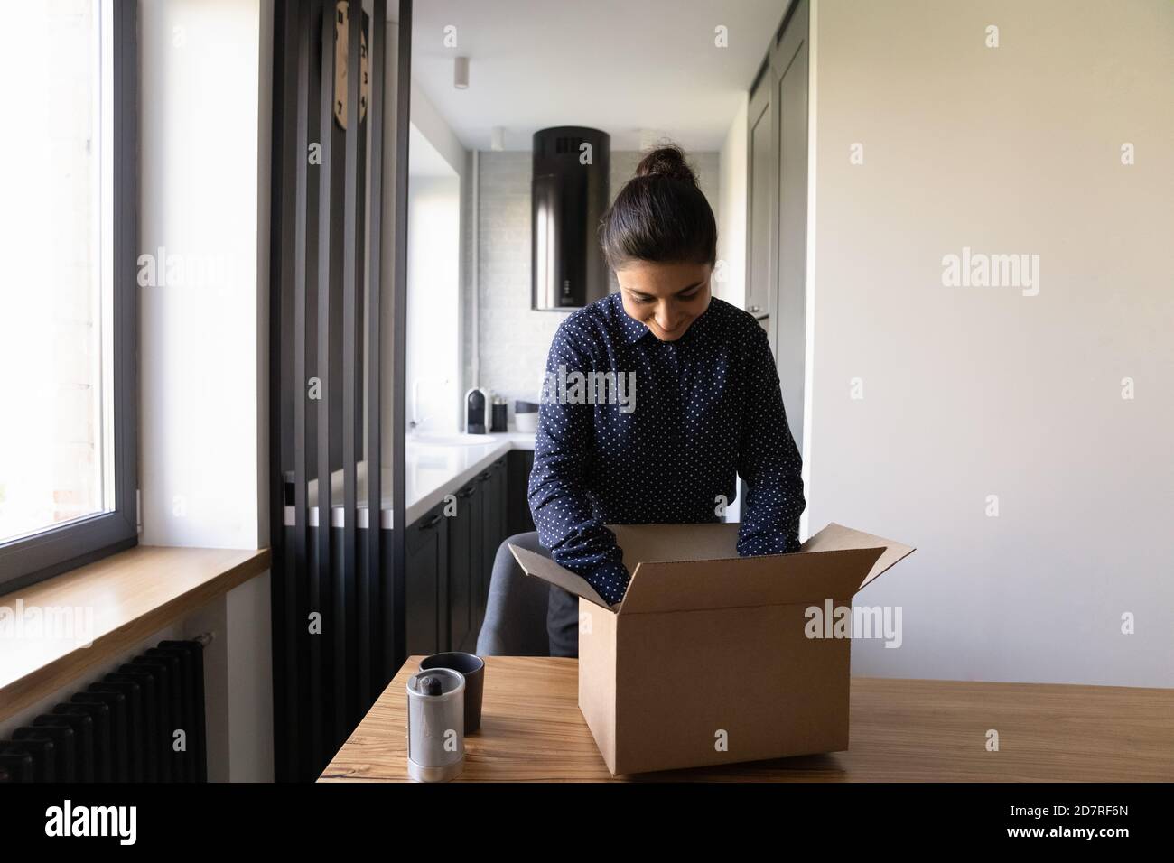 Eccitato donna indiana disimballare la scatola con ordine del Internet Foto Stock