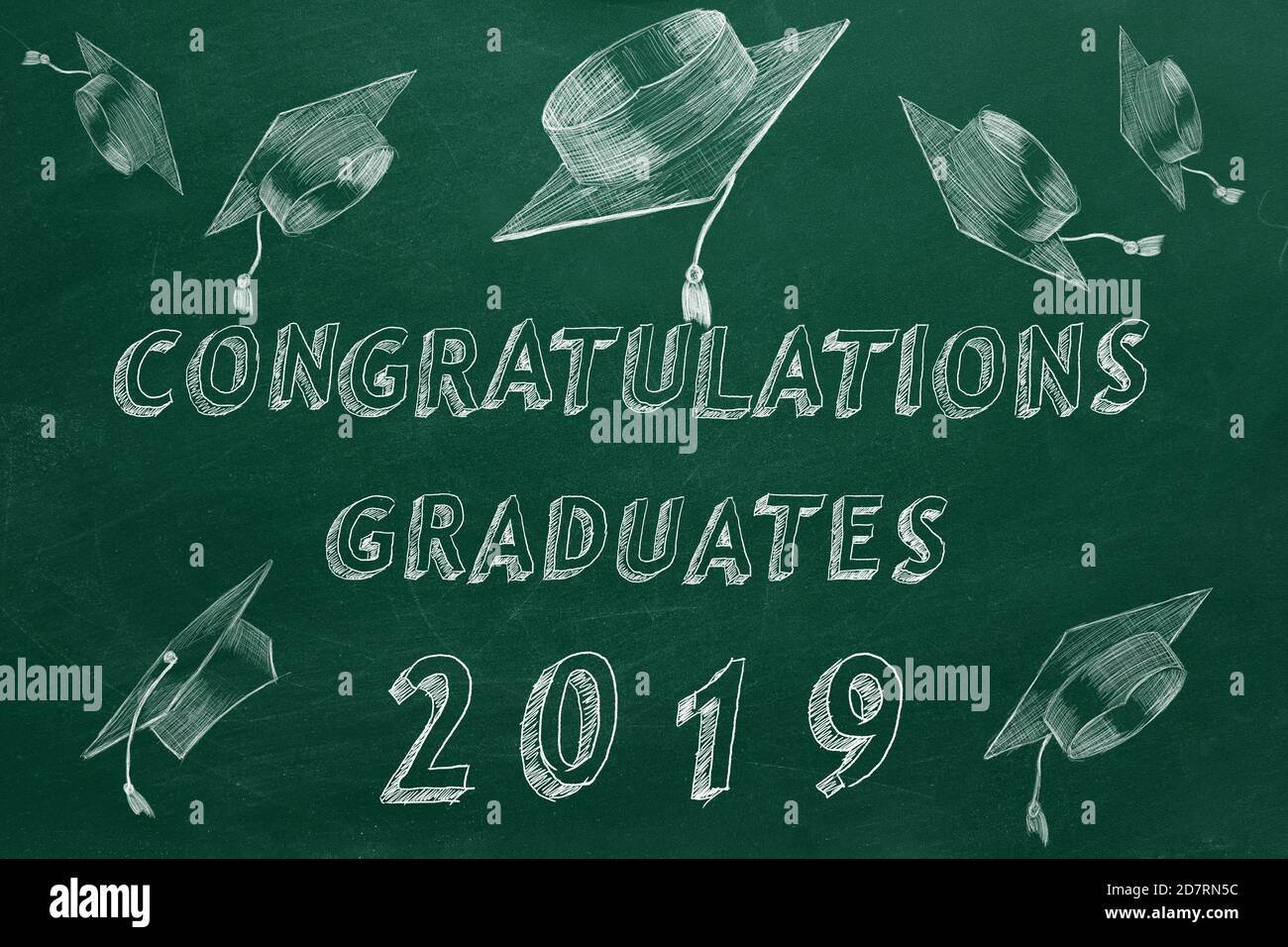 Testo di disegno a mano 'Congratulazioni laureati. 2019.' e tappi graduati sulla lavagna verde. Foto Stock