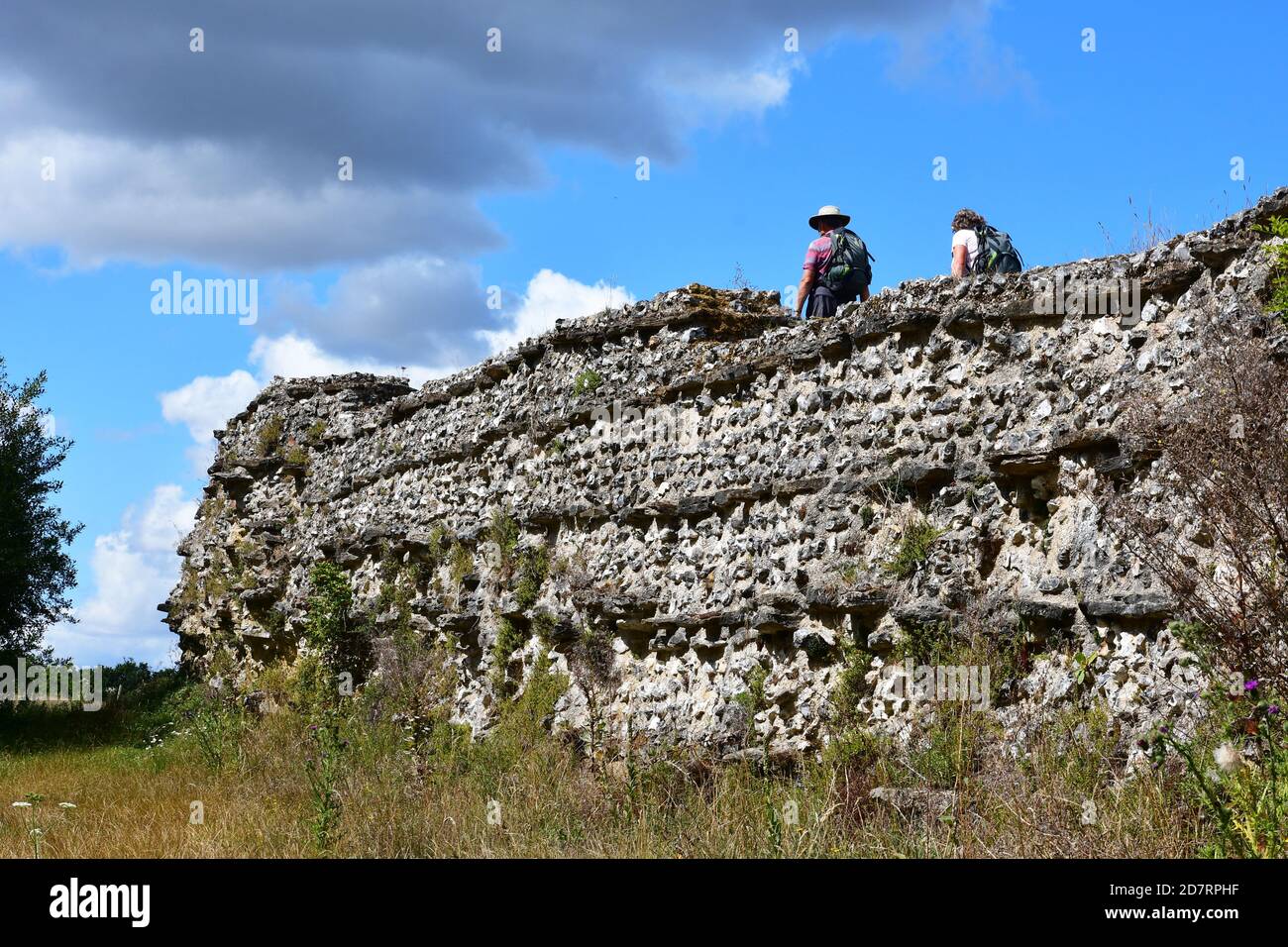 Coppia che cammina lungo la cima delle mura romane di Silchester, Silchester, Hampshire, Regno Unito Foto Stock