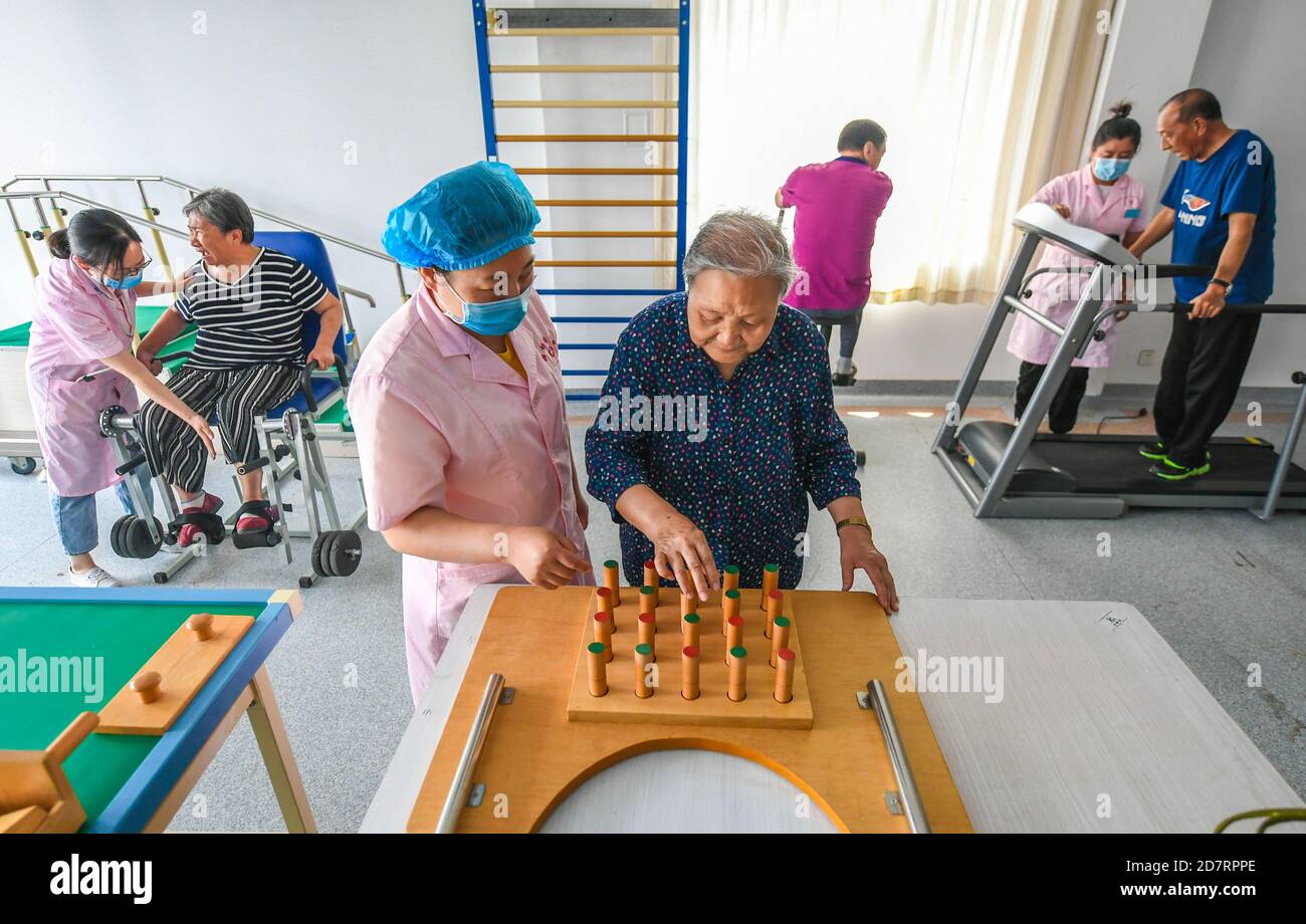 (201025) -- PECHINO, 25 ottobre 2020 (Xinhua) -- gli anziani fanno esercizi di riabilitazione con l'aiuto di personale medico in un centro di assistenza degli anziani della comunità a Langfang City, nella provincia di Hebei della Cina settentrionale, 12 giugno 2020. (Xinhua/li Xiaoguo) Foto Stock