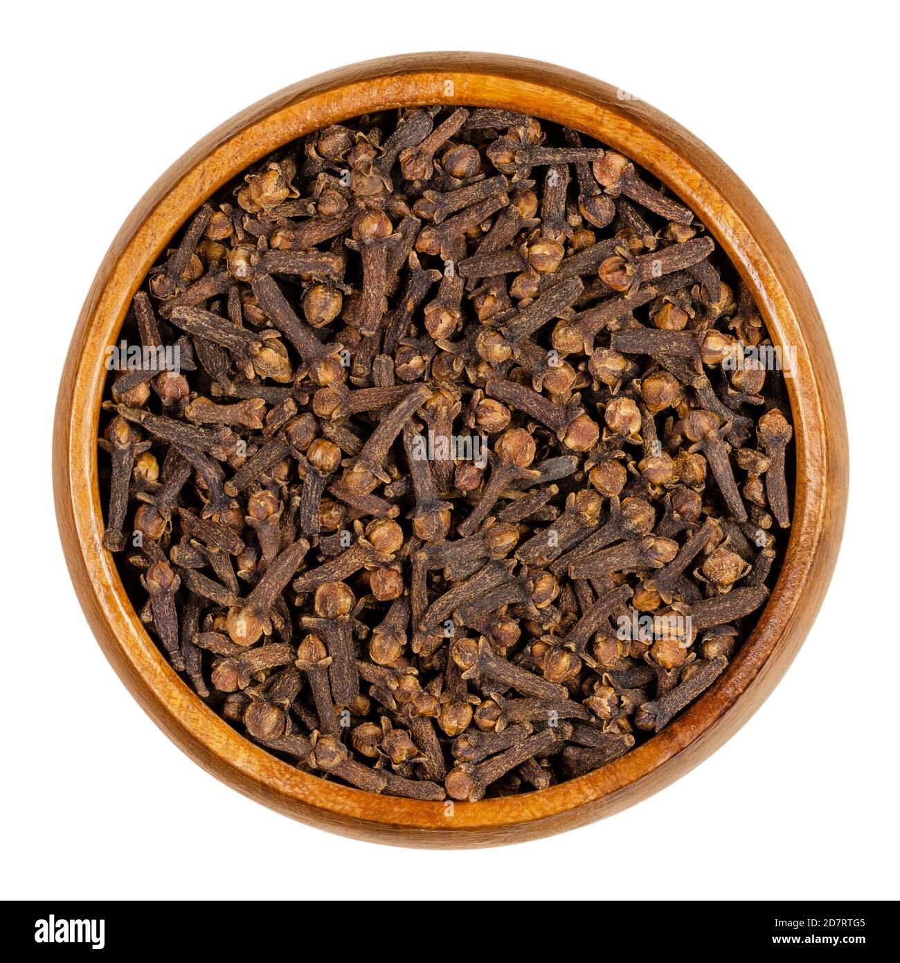 Chiodi di garofano in una ciotola di legno. Boccioli di fiori aromatici secchi dell'albero Syzygium aromaticum, utilizzati come spezie, nelle sigarette e per creare un pomander. Foto Stock