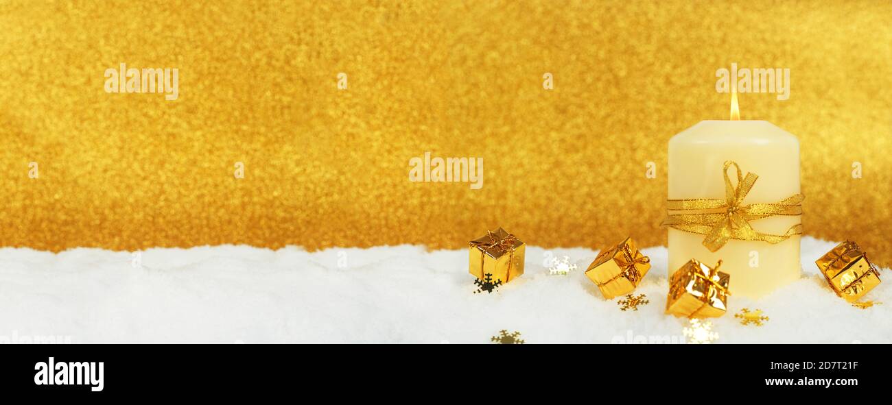 Christmas candle con golden decorazioni di Natale nella neve su sfondo glitter Foto Stock
