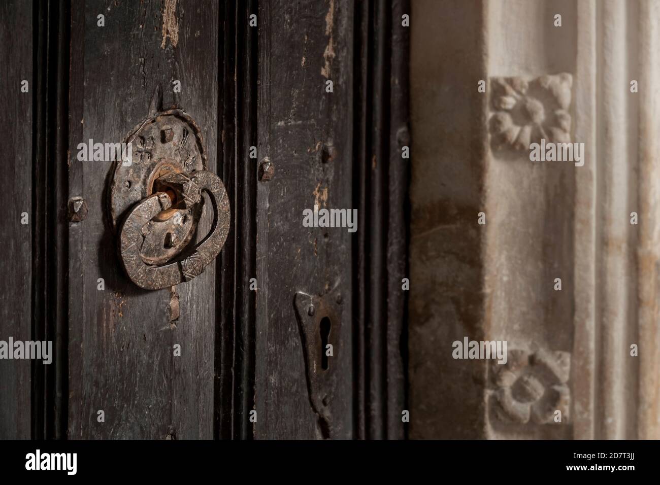 Antica maniglia della porta della chiesa e serratura a chiave con sezione di cornice porta scolpita in pietra Foto Stock