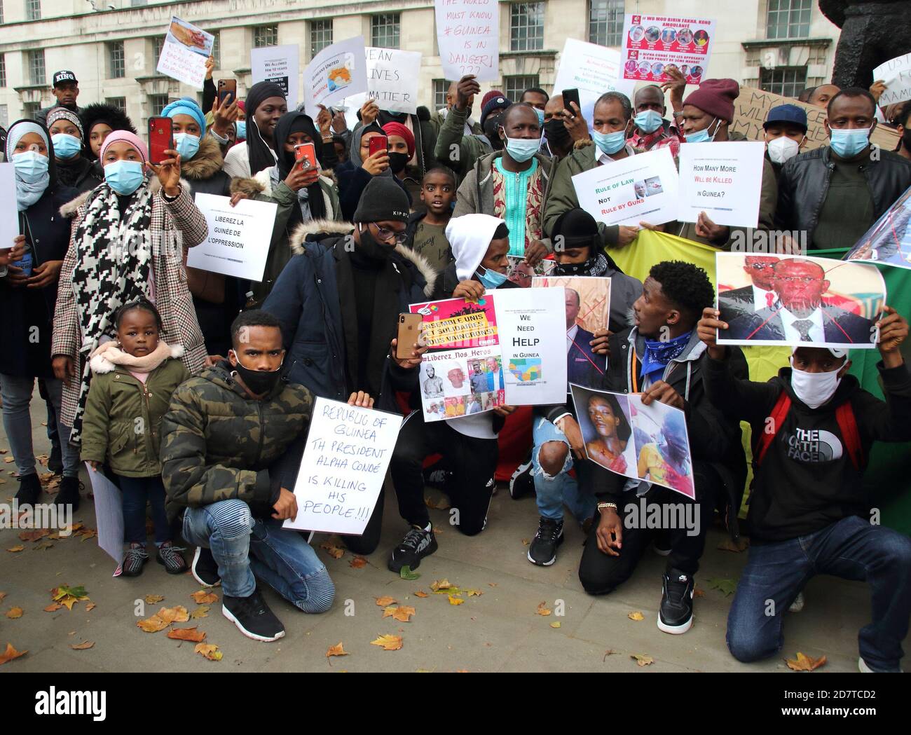 I manifestanti che indossano maschere tengono in mano cartelli e ritratti delle vittime dichiarate del regime durante il rally.Guineani nel Regno Unito protestano fuori Downing Street dopo che il presidente della Guinea Alpha Conde è stato rieletto con le rivendicazioni dell'opposizione che l'elezione è stata rigata. Foto Stock