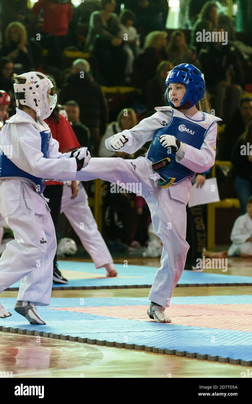 I bambini di dieci anni che competono in un torneo di Taekwondo indossando un dobok e attrezzature di protezione. Foto Stock