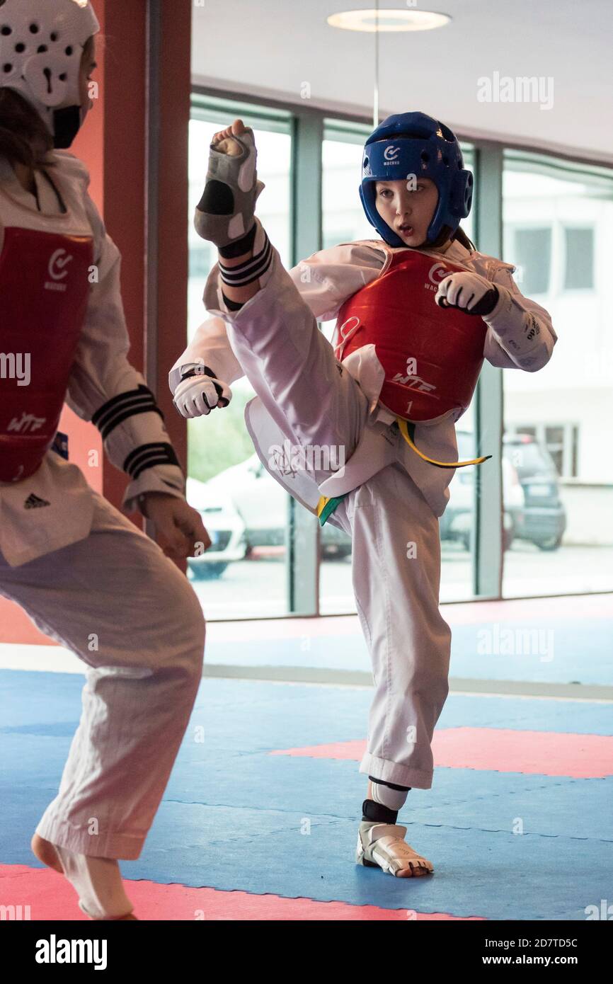 Ragazza di dieci anni che pratica Taekwondo indossando un dobok e attrezzature di protezione. Foto Stock