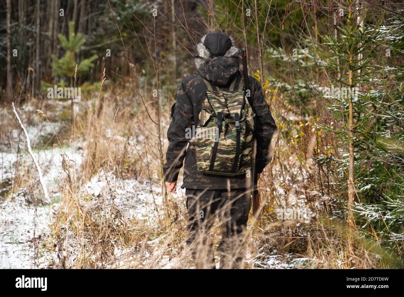 Hunter con una pistola e uno zaino in inverno foresta Foto Stock