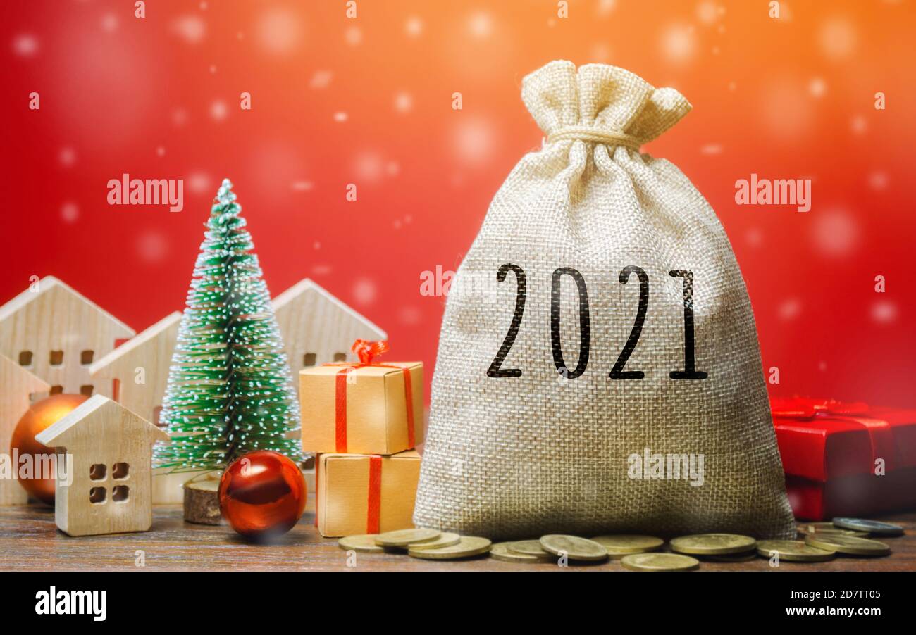 Borsa di denaro 2021, albero di Natale, case in miniatura e regali. Capodanno o Natale vacanza invernale. Accumulare denaro e pianificare un budget. Business e wi-fi Foto Stock