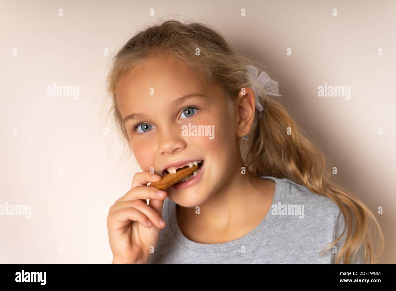 Bambina carina gusti biscotti, bocca senza denti, Foto Stock