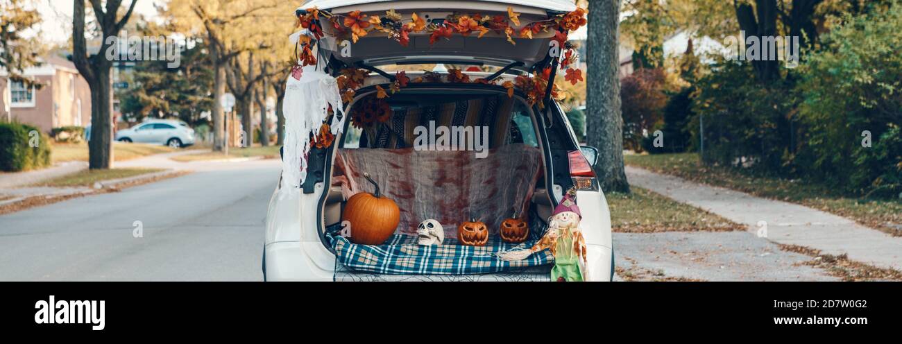 Trick o tronco. Bagagliaio bianco per auto decorato per Halloween. Decorazioni autunnali con zucche rosse e foglie gialle per le vacanze all'aperto di ottobre. Alternativa Foto Stock
