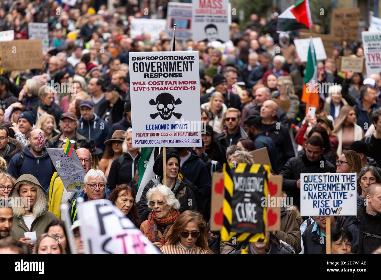 Cartelli tenuti sopra la folla in marcia durante un rally anti-lockdown a Londra, 24 ottobre 2020 Foto Stock