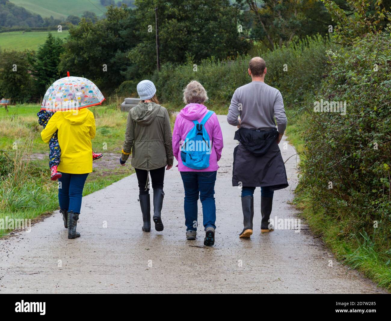 Famiglia che va per una passeggiata di campagna in pioggia e freddo meteo Foto Stock