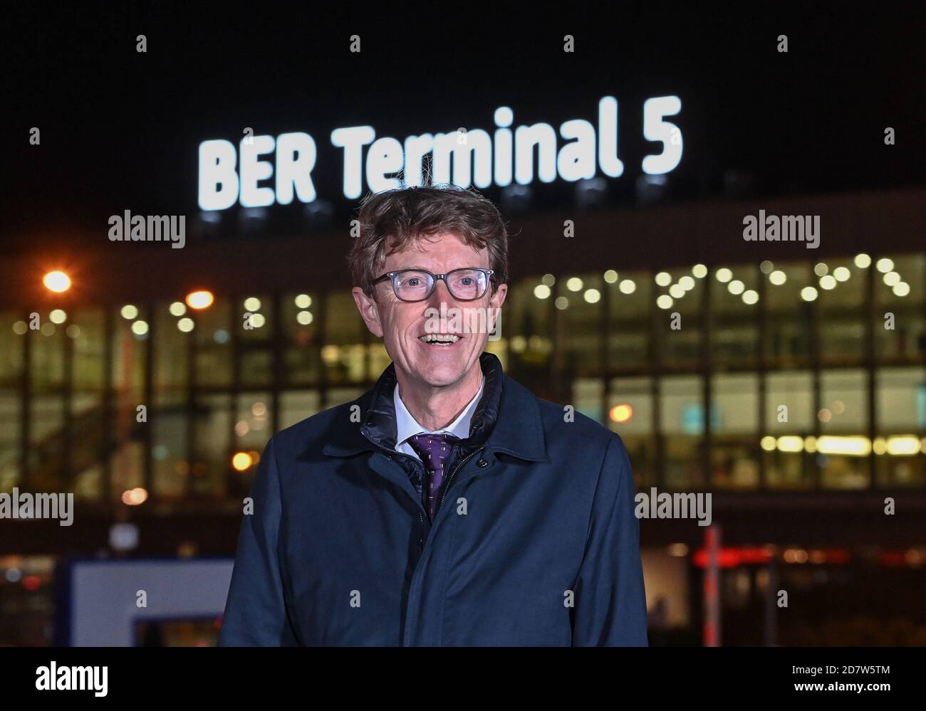 25 ottobre 2020, Brandeburgo, Schönefeld: Engelbert Lütke Deldrup, presidente del consiglio di amministrazione di Flughafen Berlin Brandenburg GmbH, si trova di fronte alla nuova scritta "BER Terminal 5" sul tetto dell'ex aeroporto di Berlino Schönefeld la sera successiva all'apertura. Gli aeroporti di Berlino riceveranno la nuova sigla BER. Pochi giorni prima dell'apertura del nuovo aeroporto di capitale, i codici precedenti TXL (Tegel) e SXF (Schoenefeld) non saranno più utilizzati quando l'orario invernale cambia. L'apertura del Capital Airport BER è prevista per il 31.10.2020. Foto: Patrick Pleul/dpa- Foto Stock