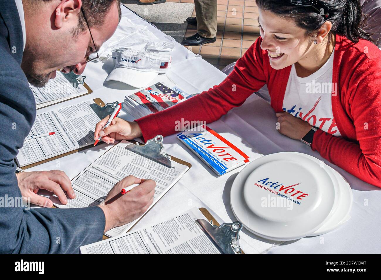 Miami Florida,guida di registrazione del voter,donna ispanica femmina,ActivoteAmerica.com,man registrazione compilando il modulo completando la scrittura,politica di voto Foto Stock