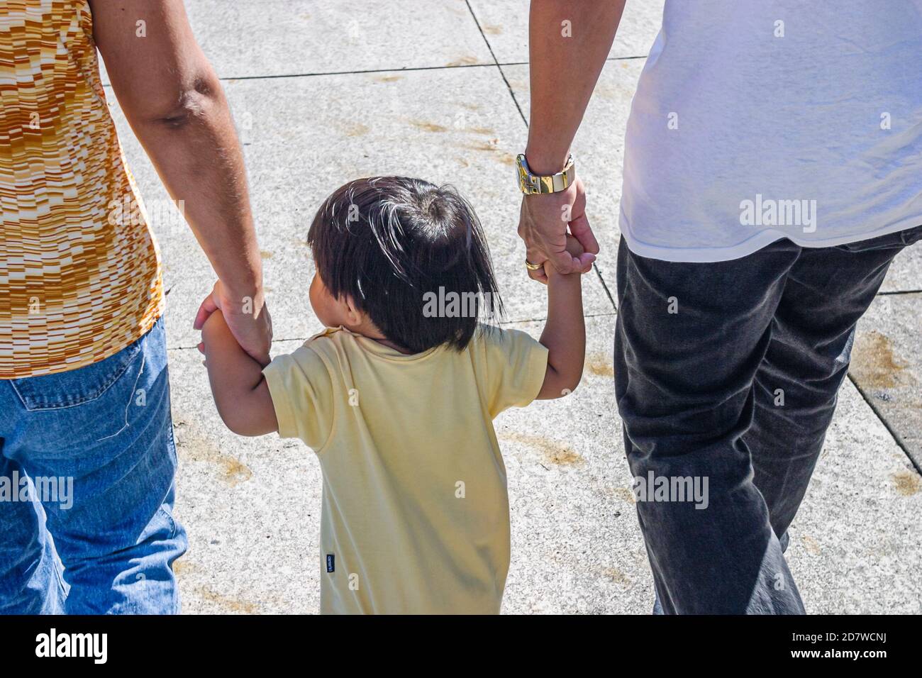 Miami Florida, Festival di Capodanno cinese, bambino ragazza asiatica tiene le mani dei genitori, Foto Stock