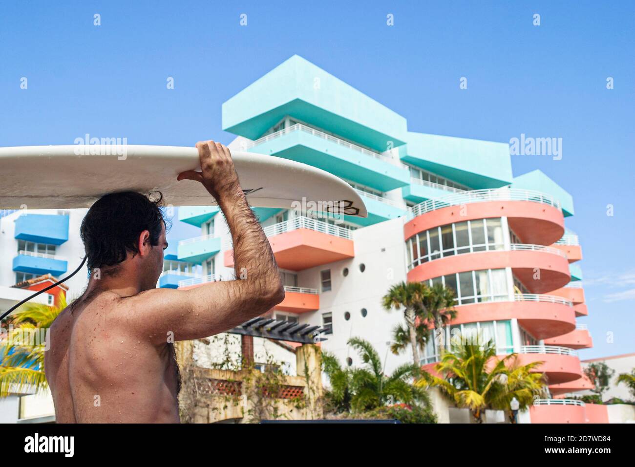 Miami Beach Florida, South Beach, Ocean Drive, Surfer Surfboard trasporto testa di bilanciamento, condominio edificio residenze, Foto Stock